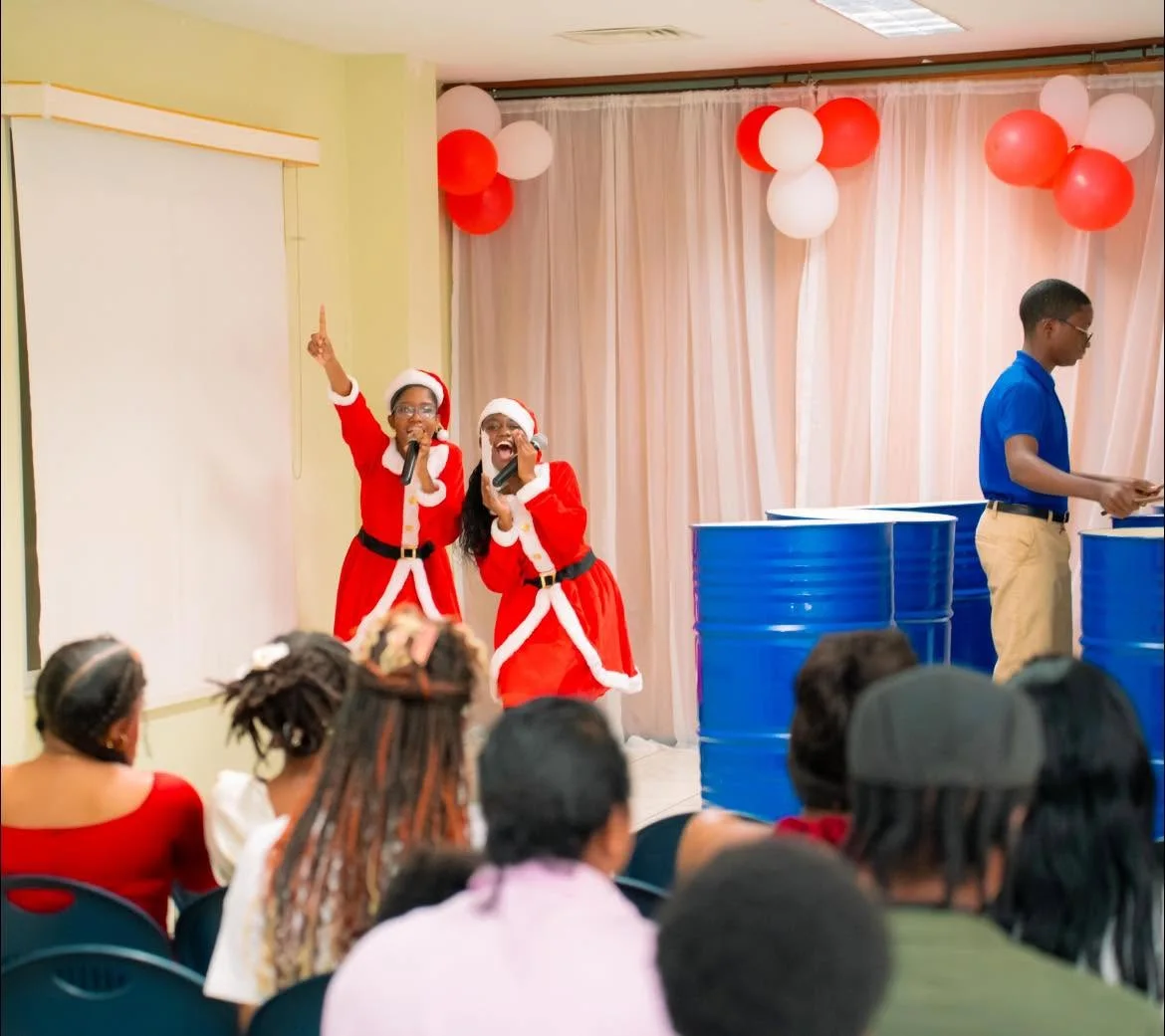 Two singers in festive outfits at the Night of Caroling